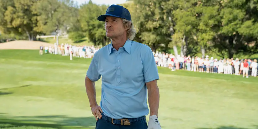 Pryce on the golf course, hand on his hip in Stick.
